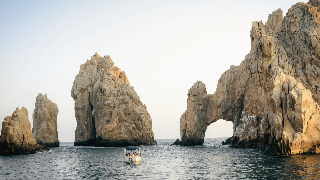 Vista del mar azul cristalino en Los Cabos, México, con sus imponentes formaciones rocosas emergiendo del agua.
