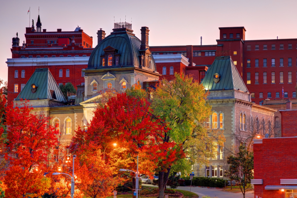 Foto de Quebec con árboles en tonos otoñales y la ciudad al fondo.