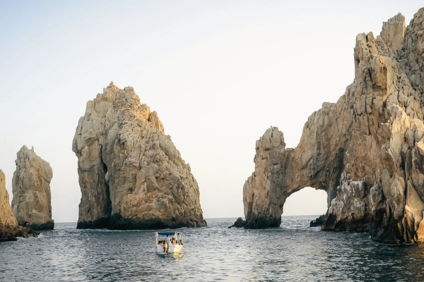 Vista del mar azul cristalino en Los Cabos, México, con sus imponentes formaciones rocosas emergiendo del agua.