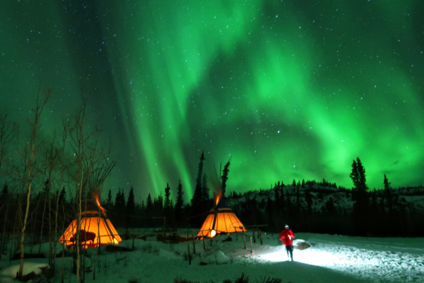 Foto de las auroras boreales iluminando el cielo nocturno en Whitehorse, Canadá.