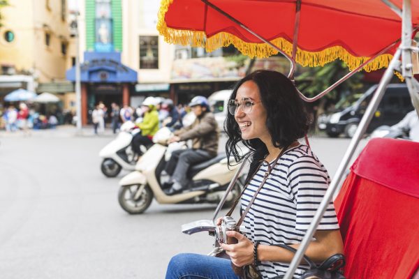 Vietnam, Hanoi, feliz joven en un riksha explorando la ciudad